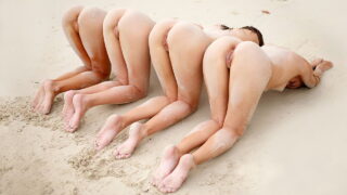 Cuatro hermosas modelos adolescentes disfrutan desnudas en la playa