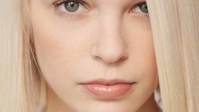 Modelo rubia sexy se desnuda y se masturba en la cama